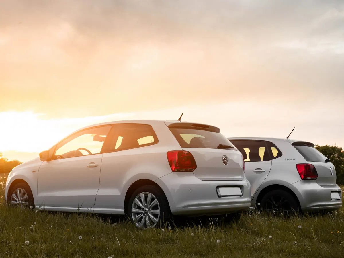Two compact hatchbacks parked at sunset